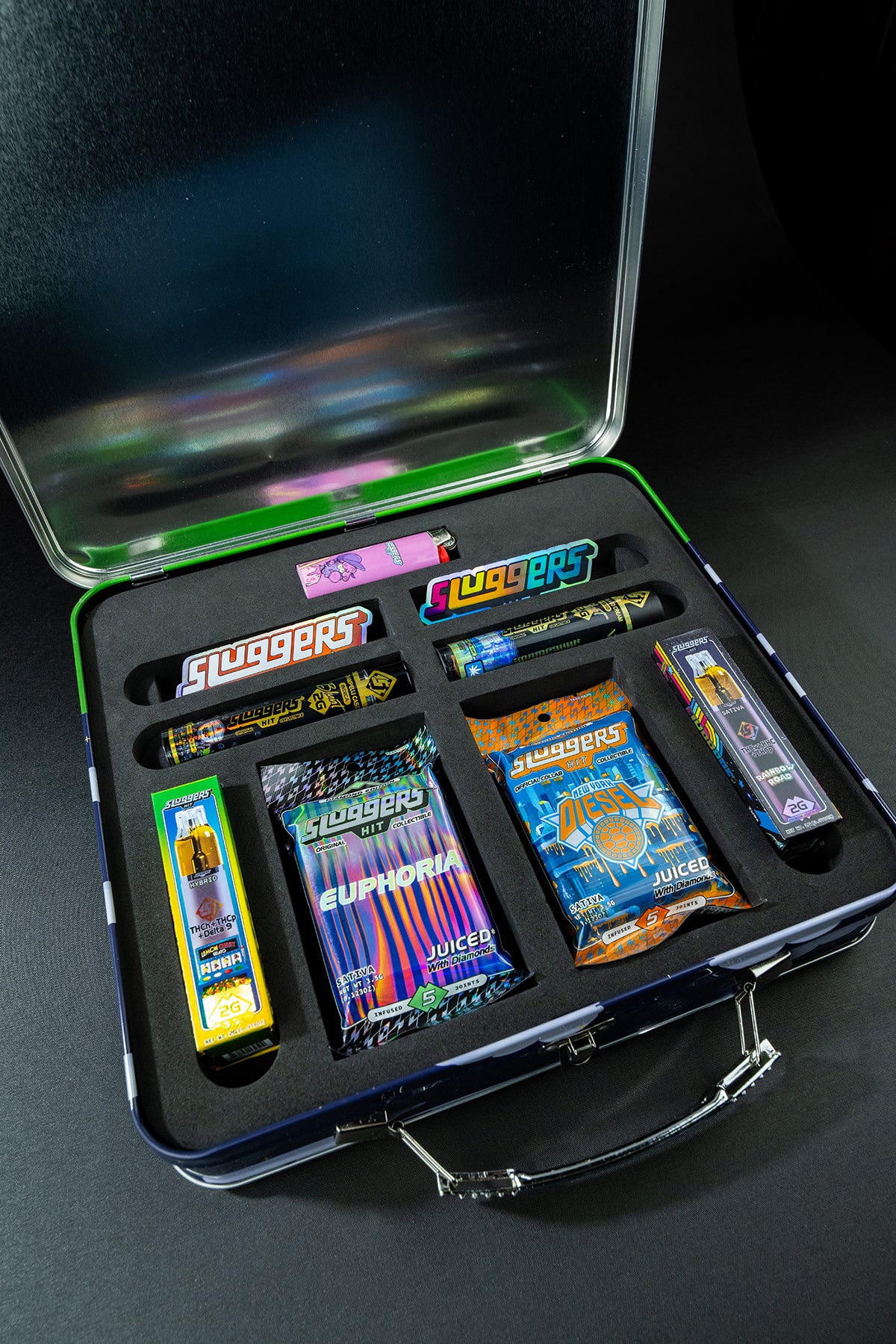 Sluggers cannabis product collection displayed in black briefcase with multiple colorful packages